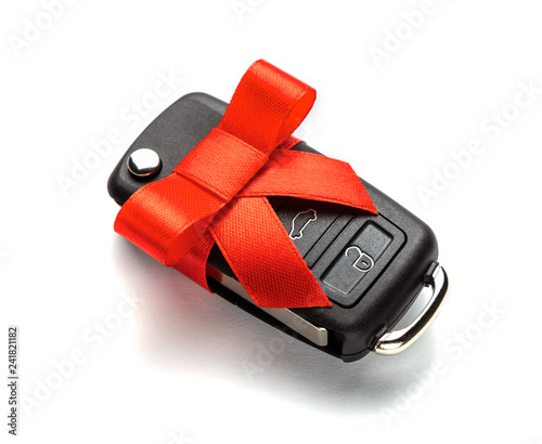 Gift Car keys with remote control alarm with red ribbon with bow. Isolated on white background.