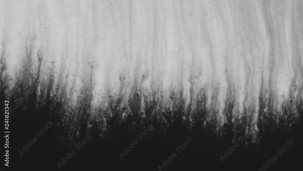 Slow motion closeup black ink border spreading on wet paper top view