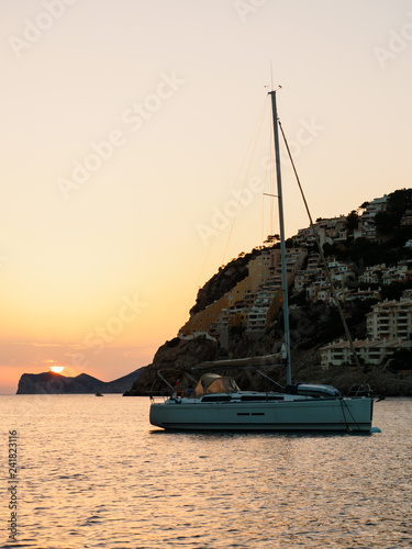 Velero fondeado durante una puesta de sol en el Puerto de Andratx, Mallorca photo