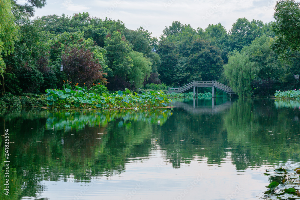 Landscape with trees and bridge and reflections in water near West Lake, Hangzhou, China