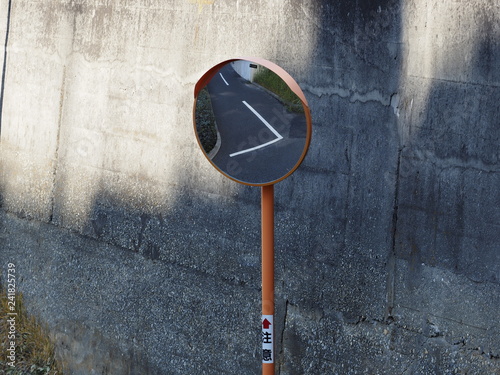 фотографія convex traffic mirror at a road curve
