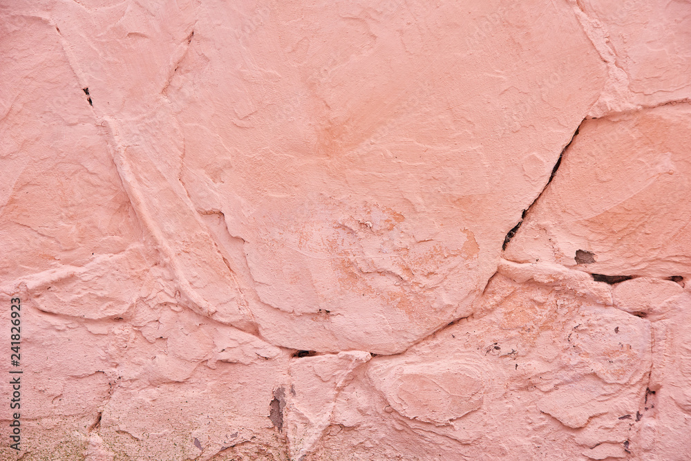 Textured background pink cracked plaster partially sprinkled with a dark rose shaded cracked wall. Grunge background Textured background pink cracked plaster partially sprinkled with a dark rose shaded cracked wall. Grunge background