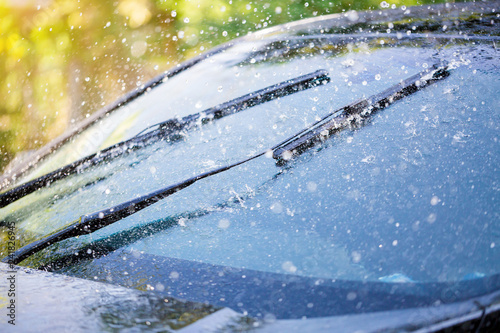 Car windshield with rain drops and frameless wiper blade