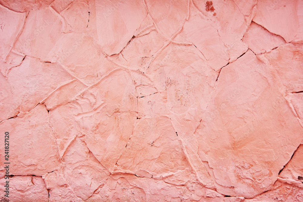 Textured background pink cracked plaster partially sprinkled with a dark rose shaded cracked wall. Grunge background Textured background pink cracked plaster partially sprinkled with a dark rose shaded cracked wall. Grunge background