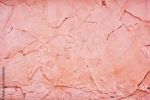 Textured background pink cracked plaster partially sprinkled with a dark rose shaded cracked wall. Grunge background
