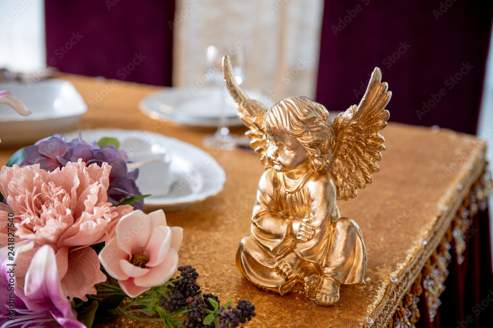 Served table with a Golden statue of an angel