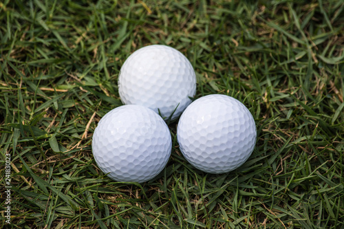 Golf balls are on the grass inside a golf course in Thailand.