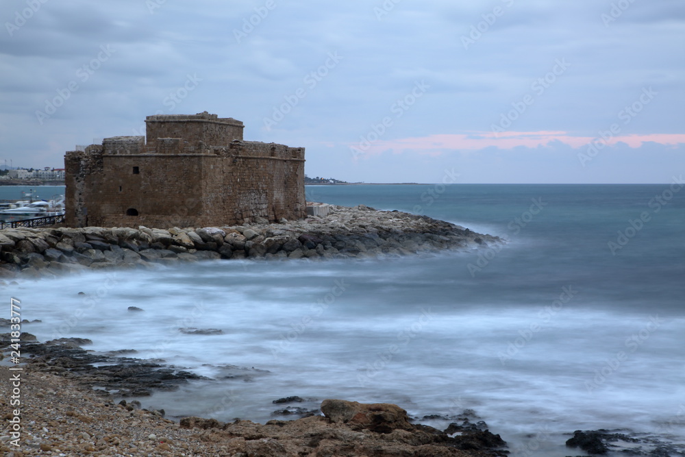 Beautiful landscape with Mediterranean Sea bay in Pafos, Cyprus, medieval fortified castle on shore, horizon, long exposure