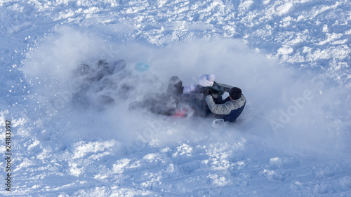 People sledding from the mountain in winter