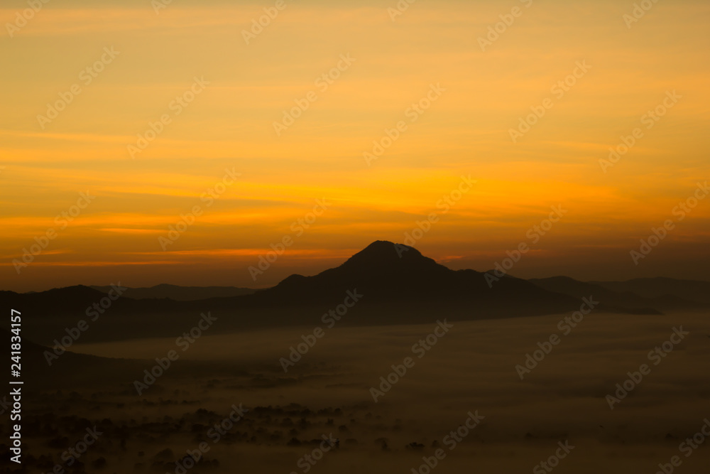 Beautiful sky sunrise. Mountain layer in morning sun ray and winter fog.