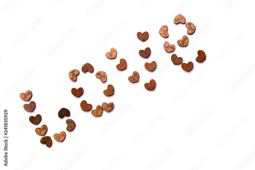 The word love is laid out from a variety of wooden hearts