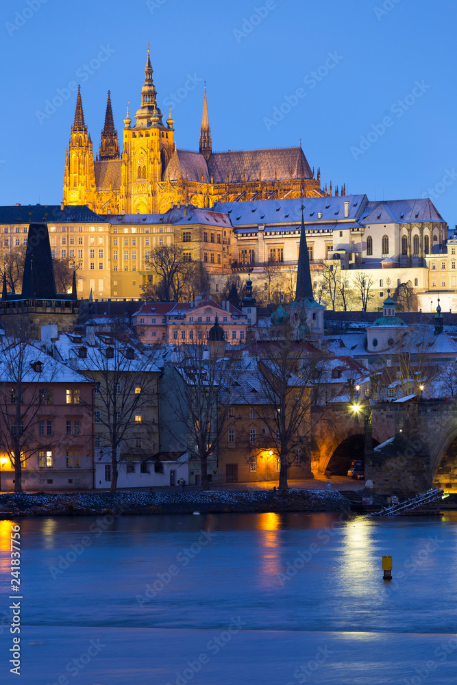 Night colorful snowy Christmas Prague Lesser Town with gothic Castle and Charles Bridge, Czech republic