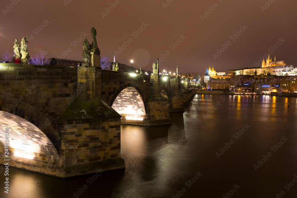 Obraz premium Night colorful snowy Christmas Prague Lesser Town with gothic Castle and Charles Bridge, Czech republic