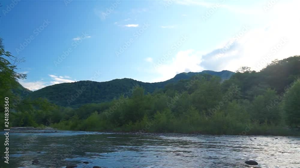Mountains covered with forest against a blue sky. Fog over river. Mountains covered with forest against a blue sky. Fog over river.