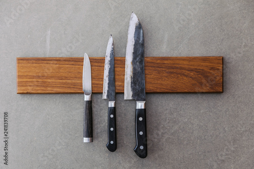 Konstfotografi Dull Japanese kitchen knives stick on magnet cover with wood on concrete wall