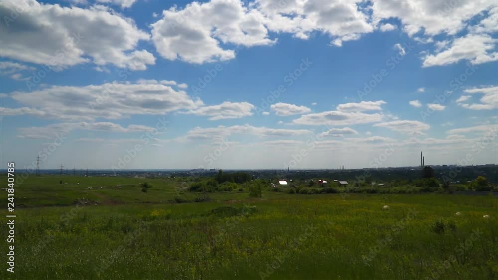 Green field and the village behind. Summer rural landscape. City on the horizon. Green field and the village behind. Summer rural landscape. City on the horizon.