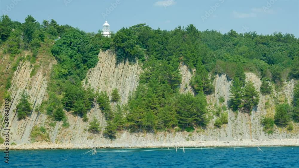 Lighthouse on the rock near coast of the sea