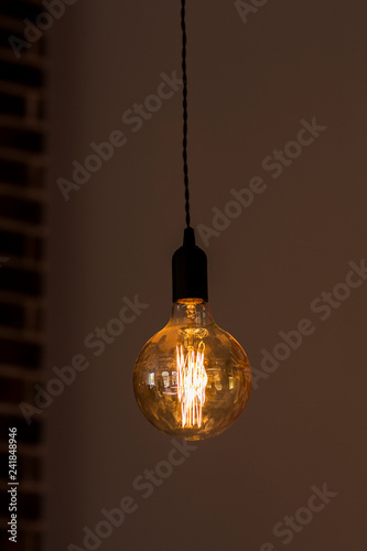 Fotografie alone hanging bulb against the background of a wall