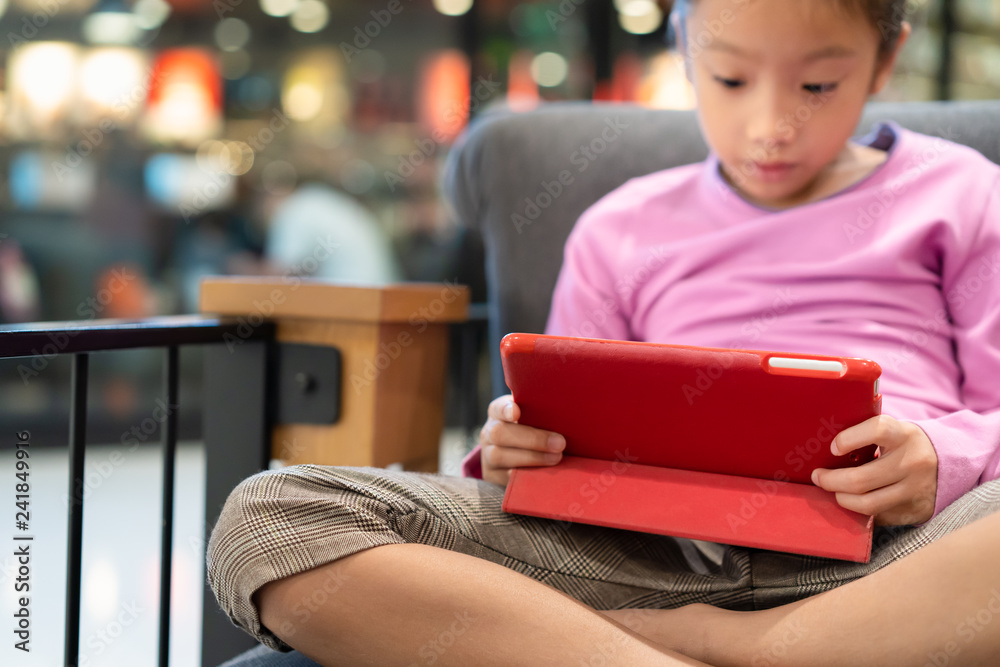 Little girl using computer tablet on sofa Little girl using computer tablet on sofa