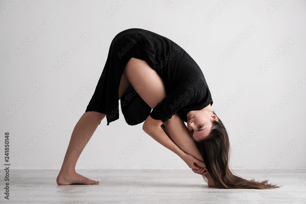 Sporty young woman doing yoga practice on white background - concept of healthy life and natural balance between body and mental development.