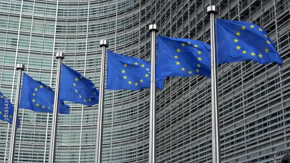 4K. European Union flags in a row waving in the wind in front of European Commission, Berlaymont building in central Brussels city, Belgium