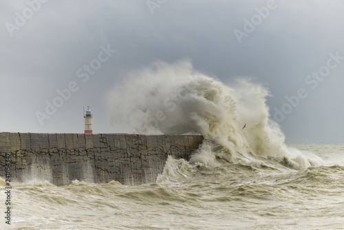 Stunning dangerous high waves crashing over harbor wall during windy Winter storm at Newhaven on English coast photo