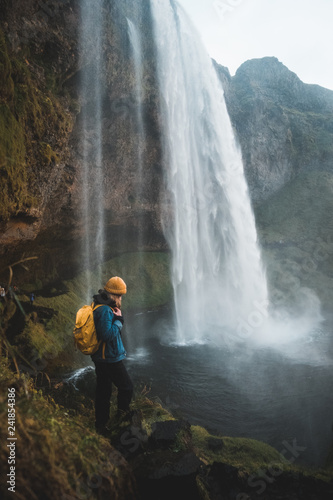 woman looking at picturesque waterfall Seljalandsfoss, Iceland. Nordic nature