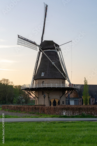 Landscape with traditional Dutch grain wind mill and blue sky on sunset, copy space