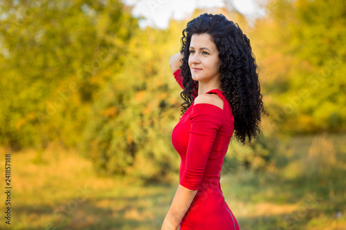 Happy beautiful young woman in red dress relax in summer park. Freedom and harmony concept