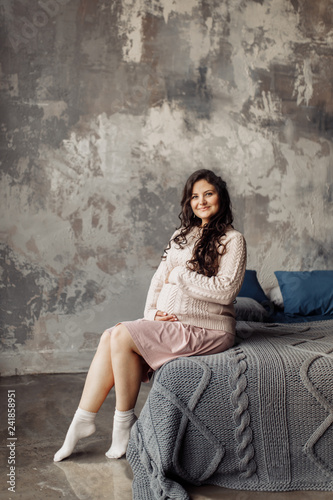 Beautiful pregnant woman in rose sweater