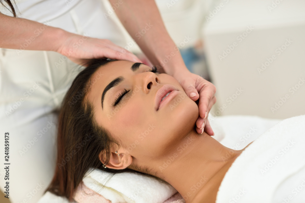 Woman receiving head massage in spa wellness center.