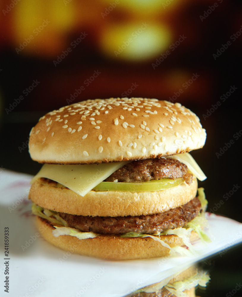 Panecillo con semillas de sésamo, dos hamburguesas, queso, tomate y lechuga. Panecillo con semillas de sésamo, dos hamburguesas, queso, tomate y lechuga.