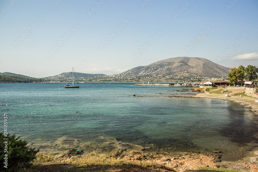 sea bay near city port with small yacht on water surface and mountain background landscape in bright vivid summer clear weather time