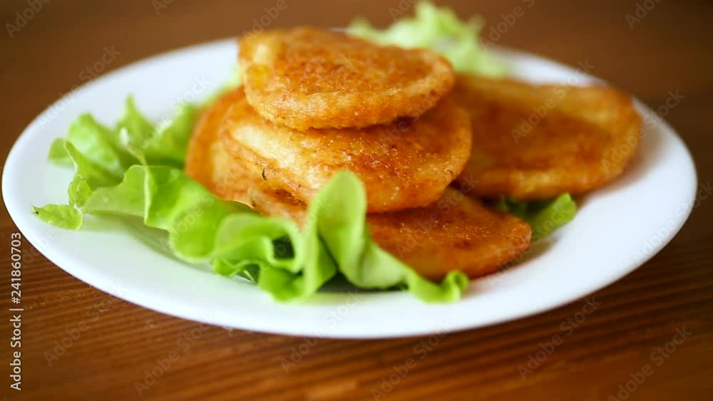 potato pancakes with lettuce leaves in a plate potato pancakes with lettuce leaves in a plate