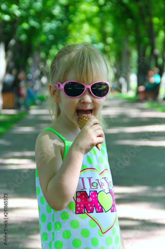 Little girl eating ice cream in city park photo