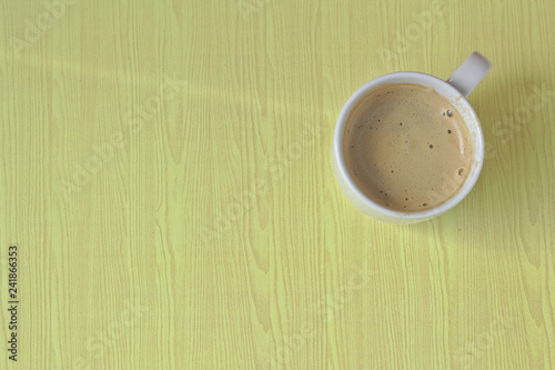 White coffee mug on brown wood background.A cup of white coffee on a wooden table in a restaurant