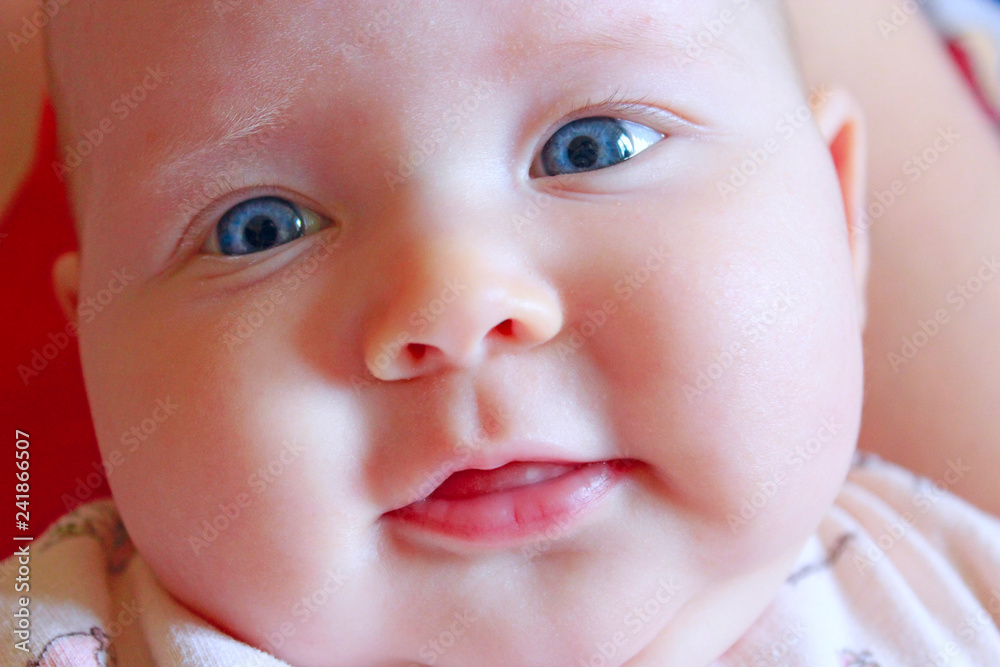 Face of smiling newborn baby lying on mother's arms Face of smiling newborn baby lying on mother's arms
