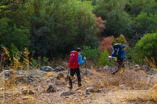 People walking along the trekking road in the mountains. Mountaineering in autumn. 