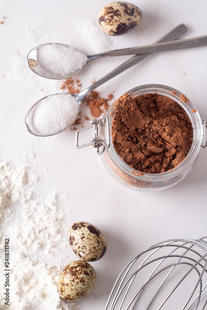cocoa, eggs, flour and sugar on a white background top view. cocoa, eggs, flour and sugar on a white background top view.