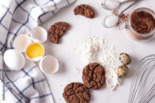 chocolate cookies and baking ingredients on white background.