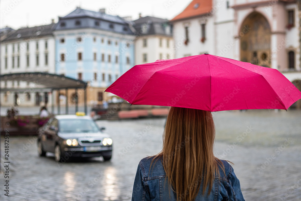 Young woman with umbrella waiting for taxi car on the street in rain Stock  Photo | Adobe Stock