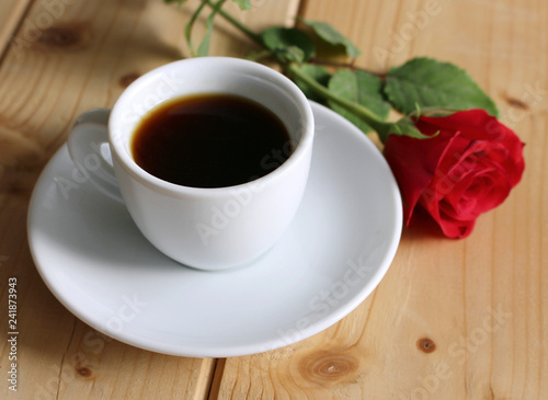 Valentines day , scene with cup of coffee and flowers red rose on wooden table. Love concept.Blurred background.