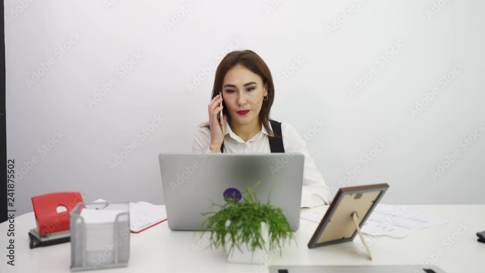 4К.  Dolly shot .Asian  serious business woman  talk by smartphone in office. 