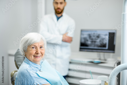 Portrait of an elder woman with healthy smile during the consultation with dentist in the dental office