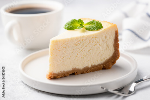 Tasty Plain New York Cheesecake Decorated With Mint Leaf. Cup of Coffee On Background