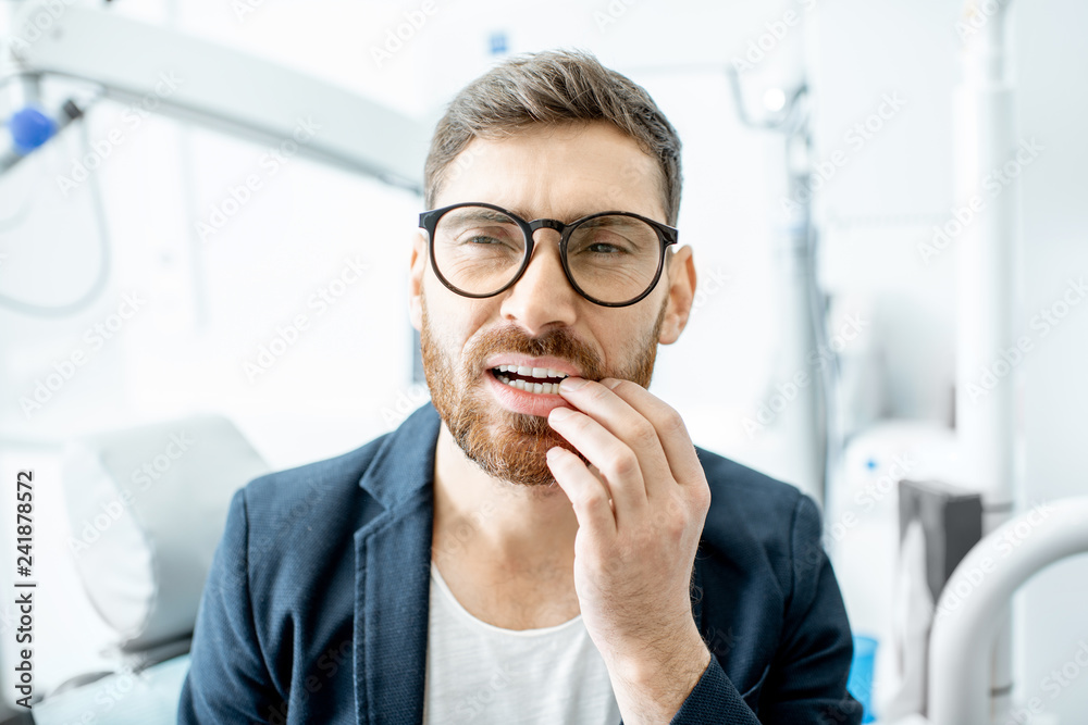 Businessman having a toothache waiting for the doctor in the dental office Businessman having a toothache waiting for the doctor in the dental office