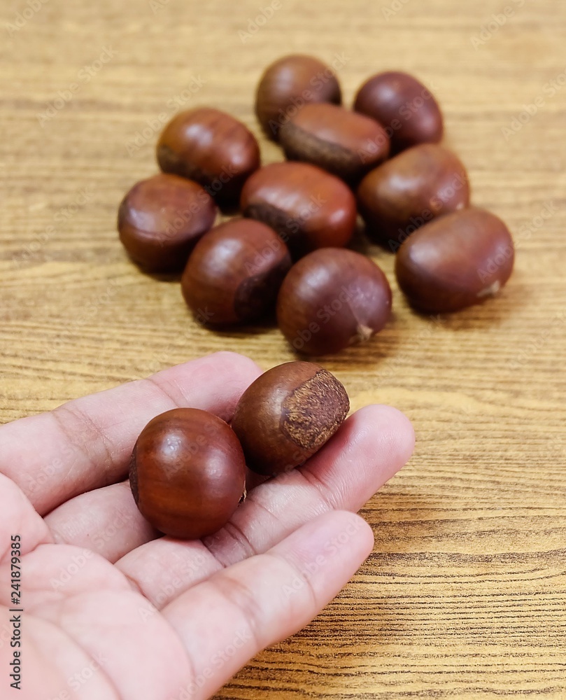 Hand Holding Roasted Chestnuts From Small Glass Hand Holding Roasted Chestnuts From Small Glass
