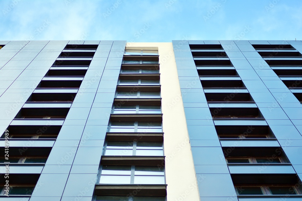 New block of modern apartments with balconies and blue sky in the background New block of modern apartments with balconies and blue sky in the background