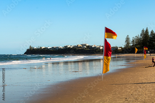 Typical Australian beach - Dicky Beach - at the Sunshine Coast in Queensland near Noosa Heads with flag, waves and white sand (Queensland, Australia) photo