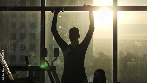 Silhouette of woman middle age doing exercise with dumbbells. photo